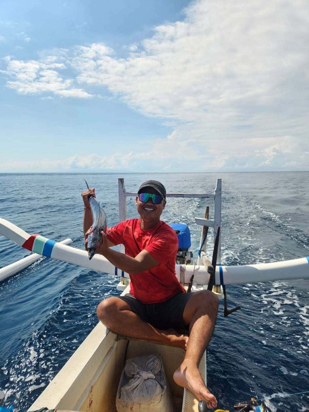 Angler holding his catch on the jukung